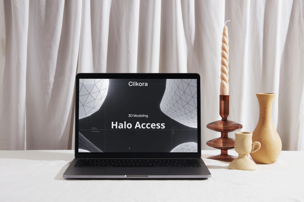 Laptop displaying 'Cilikora' on a white surface with decorative items.