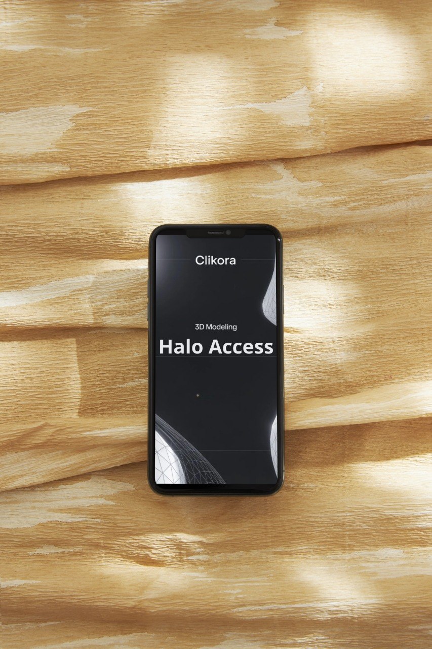 Smartphone displaying 'Clikora' and 'Halo Access' on a wooden surface